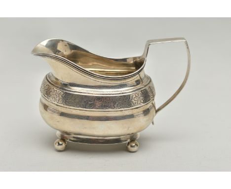 A GEORGE III SILVER HELMET SHAPED MILK JUG OF SHAPED OVAL FORM, angular handle, wriggle work and bright cut engraved decorati