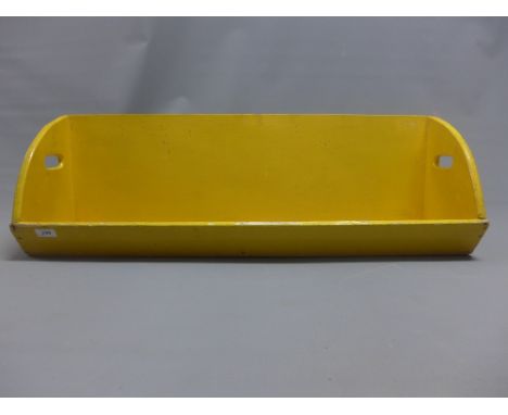 A wooden animal trough painted yellow 