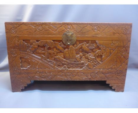 A Chinese Camphorwood trunk carved with figures in a boat