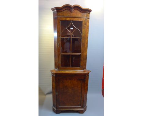 A Georgian style burr walnut corner cabinet with glazed door above cupboard door raised on carved bracket feet, H:198cm W:75c