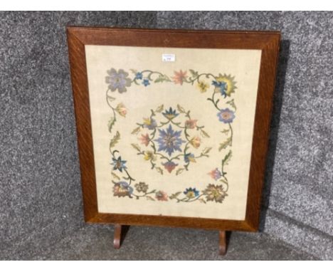 An Edwardian oak firescreen with embroidered panel
