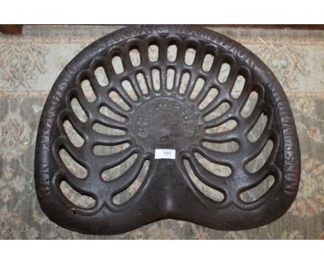 A LARGE CAST IRON TRACTOR SEAT