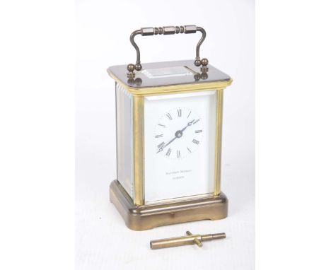 A brass cased carriage clock, Matthew Norman LondonThe case with a swing handle above a white enamel dial, Roman numerals, 11