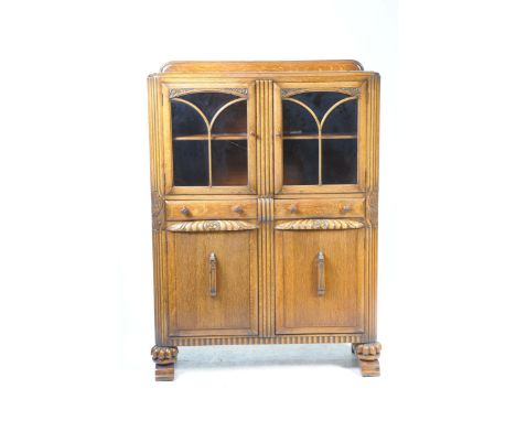 A mid 20th Century medium oak display cabinetWith a rectangular moulded top above two astragal glazed doors enclosing a singl