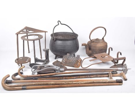 Assorted walking sticks and shooting sticks, and assorted iron wareTo include an iron couldron, trivets, flat iron, iron kett