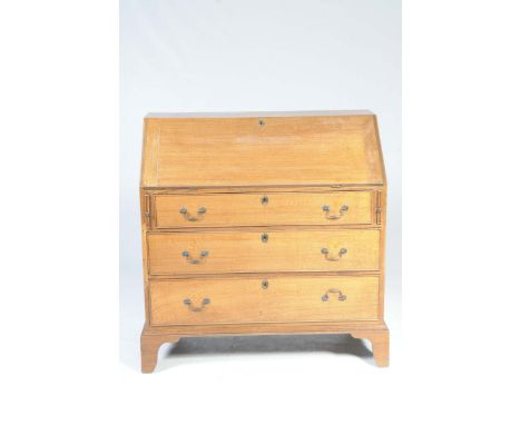 A 19th Century oak bureauWith a rectangular fall front enclosing compartmentalized interior above three graduated cockbeaded 