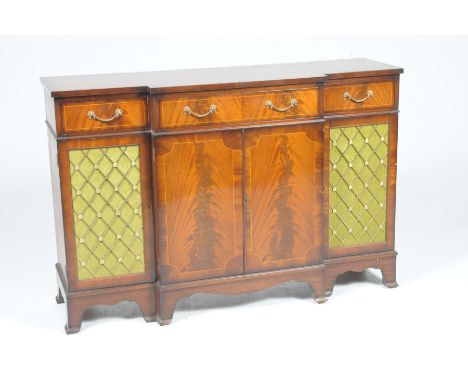A Regency style mahogany breakfront side board, 20th CenturyHaving three frieze drawers each with ornate gilt swing handles a