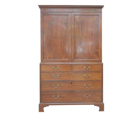 A George III mahogany linen pressWith a moulded dentil cornice above a pair of flame mahogany doors each inlaid with a crossb