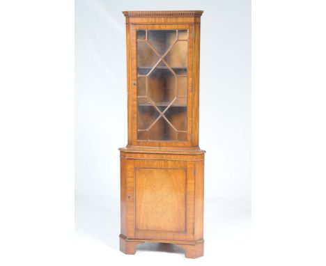 A good quality reproduction mahogany free standing corner cabinet by Bevan FunnellWith a dentil cornice above a single astrag