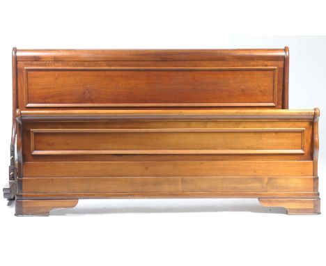 A reproduction mahogany sleigh bed With panelled foot and head boards of curved form raised on bracket feet, along with confo