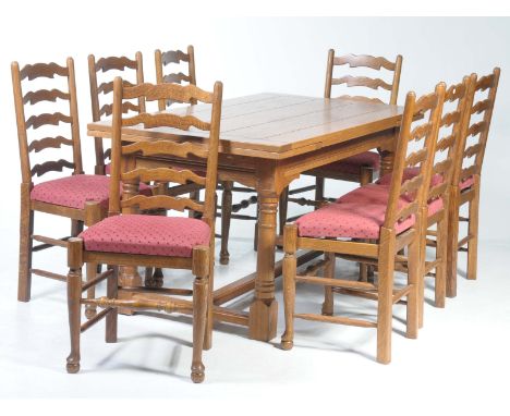 An 18th Century style medium oak drawer leaf refectory table and eight chairs, 20th CenturyThe table with a simulated plank a