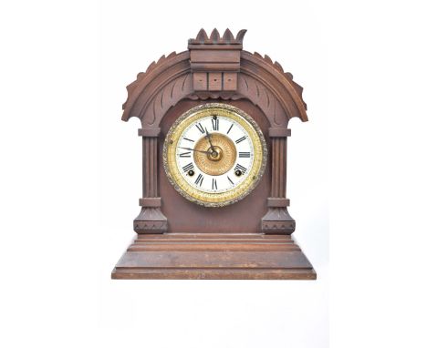 An American walnut cased bracket clock, early 20th CenturyWith a carved architectural case enclosing a gilt and enamelled dia
