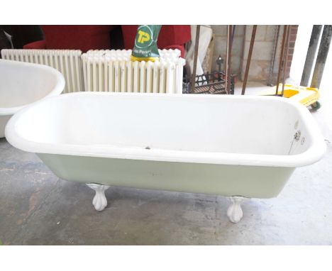 An early 20th Century cast iron and enamel bathOf typical oblong rounded form raised on four paw and ball feet, along with ba