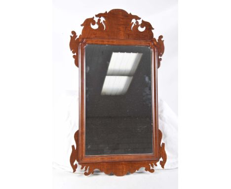 A Chippendale style mahogany wall mirrorThe rectangular plate within a channelled border and a fretwork pediment, height 73cm