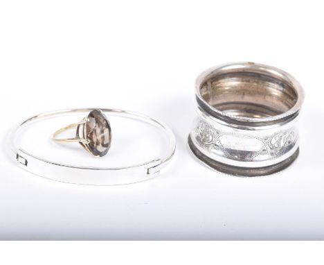 A gem-set cocktail ringTo a 9k gold shank, together with, a silver bangle and a silver napkin ring (3)