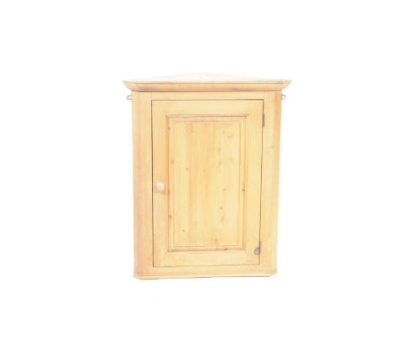 A pine hanging corner cupboardWith a single panelled door enclosing a single shelf, 82cm high.