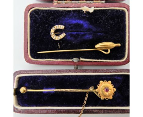 A 15ct gold and red gem brooch, a yellow metal pin in the shape of a cocoa bean, and a further pin with pearl set horseshoe  