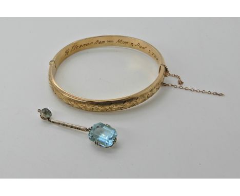 A 9ct gold bangle with a yellow metal pendant set with blue gems  Condition Report: 