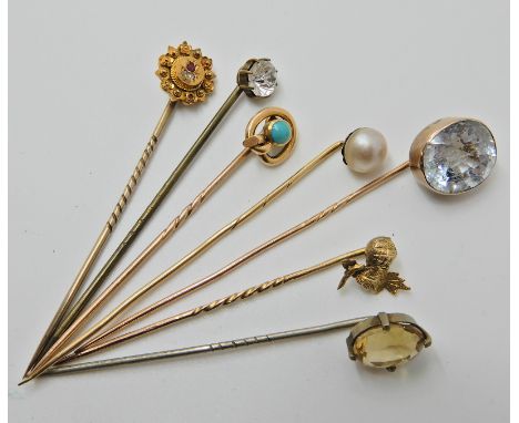A collection of yellow and white metal stick pins to include a 15ct example set with diamonds and rubies and a 9ct example se