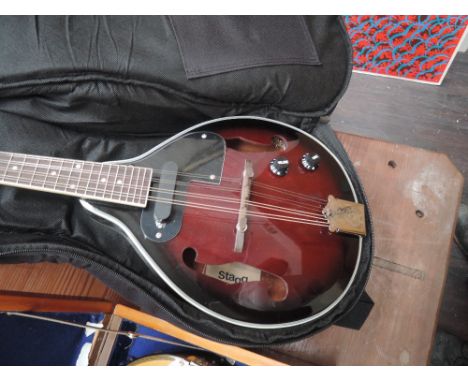 A modern electric mandolin by Stagg, with padded case and lead