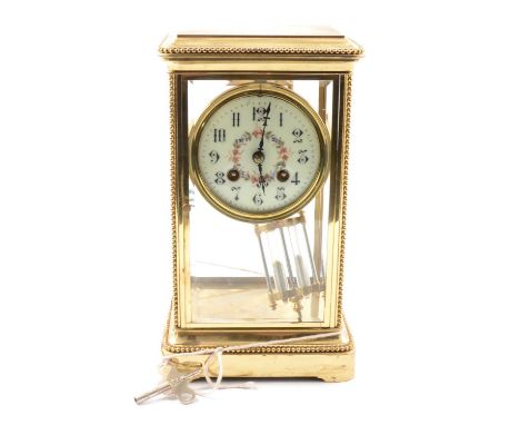 A brass 'four glass' mantel clock, floral dial, mercury compensated pendulum, the movement striking on a gong and marked Meda