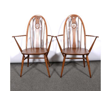 Ercol, two Swan back dining armchairs, gold and brown circular label, width 68cm.