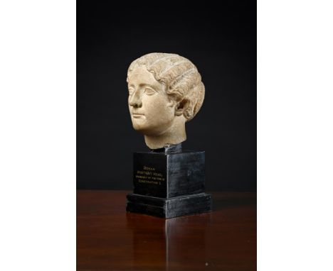A ROMAN MARBLE PORTRAIT HEAD OF A WOMAN  1ST-2ND CENTURY A.D  Later set on wooden base inscribed "Roman Portrait Head: probab
