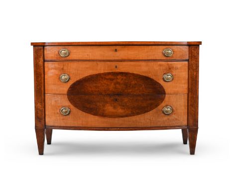A GEORGE III HAREWOOD AND BURR YEW BOWFRONT COMMODE IN THE MANNER OF INCE & MAYHEW, CIRCA 1785 The top drawer containing a fi