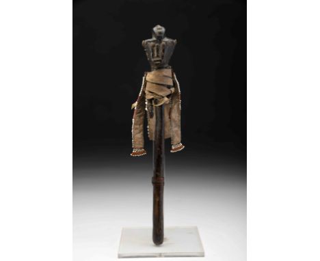 A «Muila» dance staff, wood, leather, beads, buttons, metal, carved staff top "Torso and head of woman with trilobed hairstyl