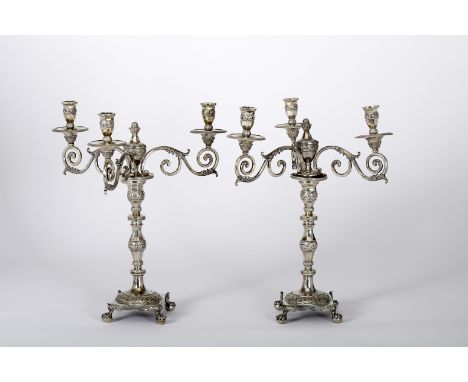 A pair of four-foot candlesticks with three-light serpentines, 833/1000 silver, decoration en relief "Flowers", square bases 