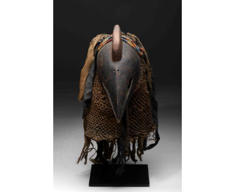 A "Bird" mask, wood, fibers, fabric, plastic and glass beads, possibly a representative mask of the species «Bucorvus cafer» 