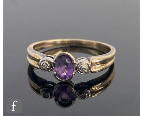 A 9ct hallmarked amethyst and diamond three stone ring, central oval amethyst flanked by diamonds to a ribbed shank, weight 2