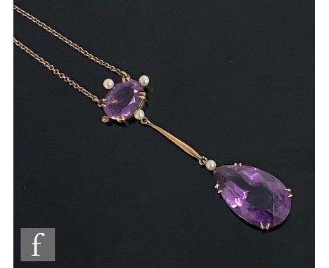 An early 20th Century 9ct two stone amethyst and seed pearl pendant, pear shaped amethyst drop below oval amethyst with pearl