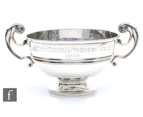 A hallmarked silver twin handled bowl, circular spread foot below plain body with presentation engraving, terminating in twin