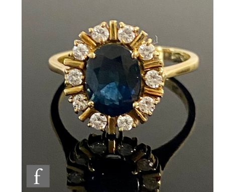 An 18ct sapphire and diamond cluster ring, central oval amethyst, length 10mm, within a ten stone diamond surround, weight 5.