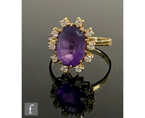 An 18ct amethyst and diamond cluster ring, central oval amethyst, length 12mm, within a ten stone diamond surround, weight 4.