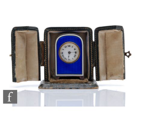 An early 20th Century French silver miniature boudoir clock, Roman numerals to a white enamelled dial, the arched case with b