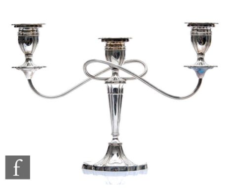 A hallmarked silver three light candelabra, shaped oval base below fluted column, twin reeded arms and conforming oval sconce