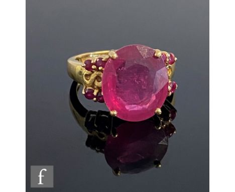 An 18ct hallmarked ruby ring, claw set central stone, length 13.5mm, with four further rubies set to each shoulder, weight 6.