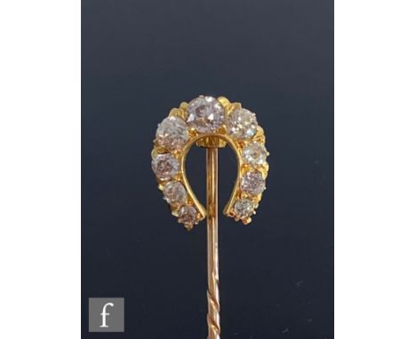 An early 20th Century diamond set horseshoe stick pin, comprising nine old cut, claw set stones, unmarked, probably 15ct and 