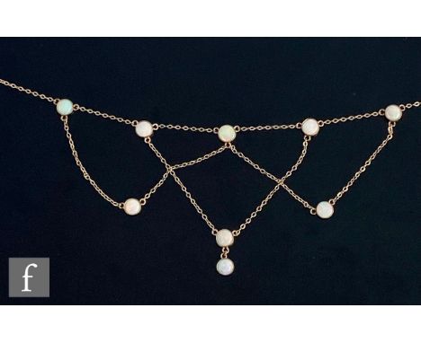 An early 20th Century 9ct opal necklet comprising nine circular opal stones united and suspended from a fine trace chain, wei