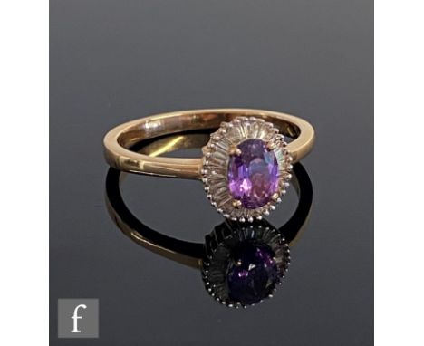 An 18ct purple sapphire and diamond cluster ring, central claw set oval sapphire within a border of tapering baguette cut dia