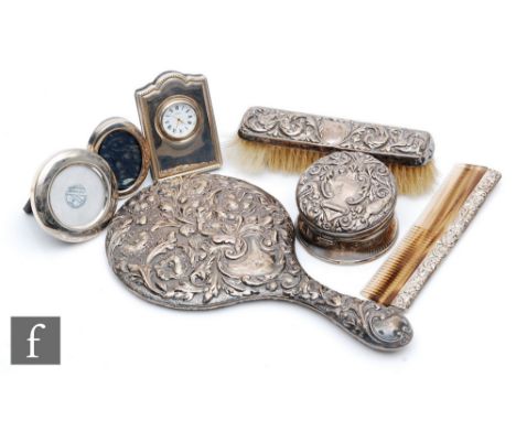 A small parcel lot of hallmarked silver to include two modern easel photograph frames and a similar clock, a three piece silv