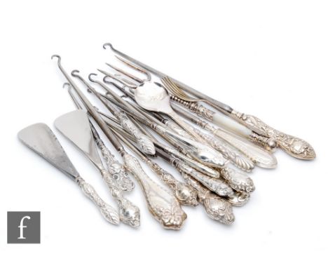 A collection of sixteen hallmarked silver handled button hooks of various styles and sizes, with two shoe horns, a silver spo