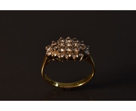 A diamond cluster ring, central raised cluster of eight round brilliant cut diamonds,surrounded by band of sixteen smaller co