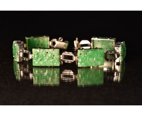A Chinese carved jade and 9ct gold panel bracelet, six rectangular carved floral panels, each divided by a faceted elongated 