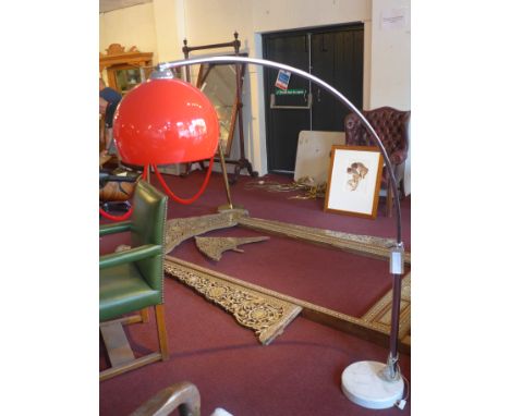 A contemporary chrome arch lamp, with red perspex shade, raised on marble base