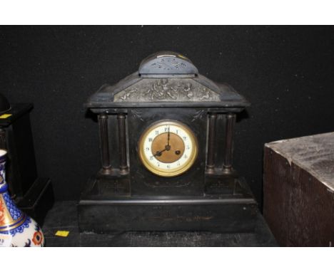 A 19th century black slate mantel clock of architectural design, the dial with white chaptering and Arabic numerals to the tw