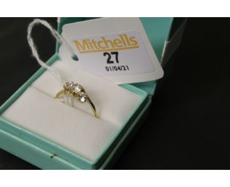A 14ct gold and white stone ring with cross-over style shank, claw set with three brilliant cut stones, the largest 0.3 carat
