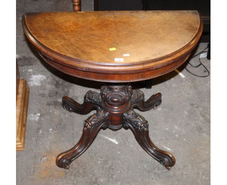 A Victorian figured walnut D Shaped card table with green baize lined folding top on turned and carved centre column and quad